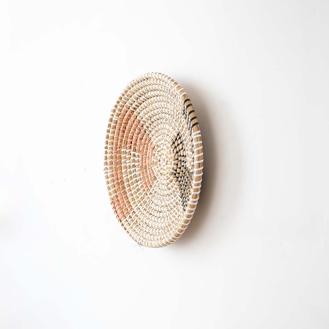 Side view of handwoven wall basket decor made of rustic natural fiber with boho abstract pattern for wall styling.