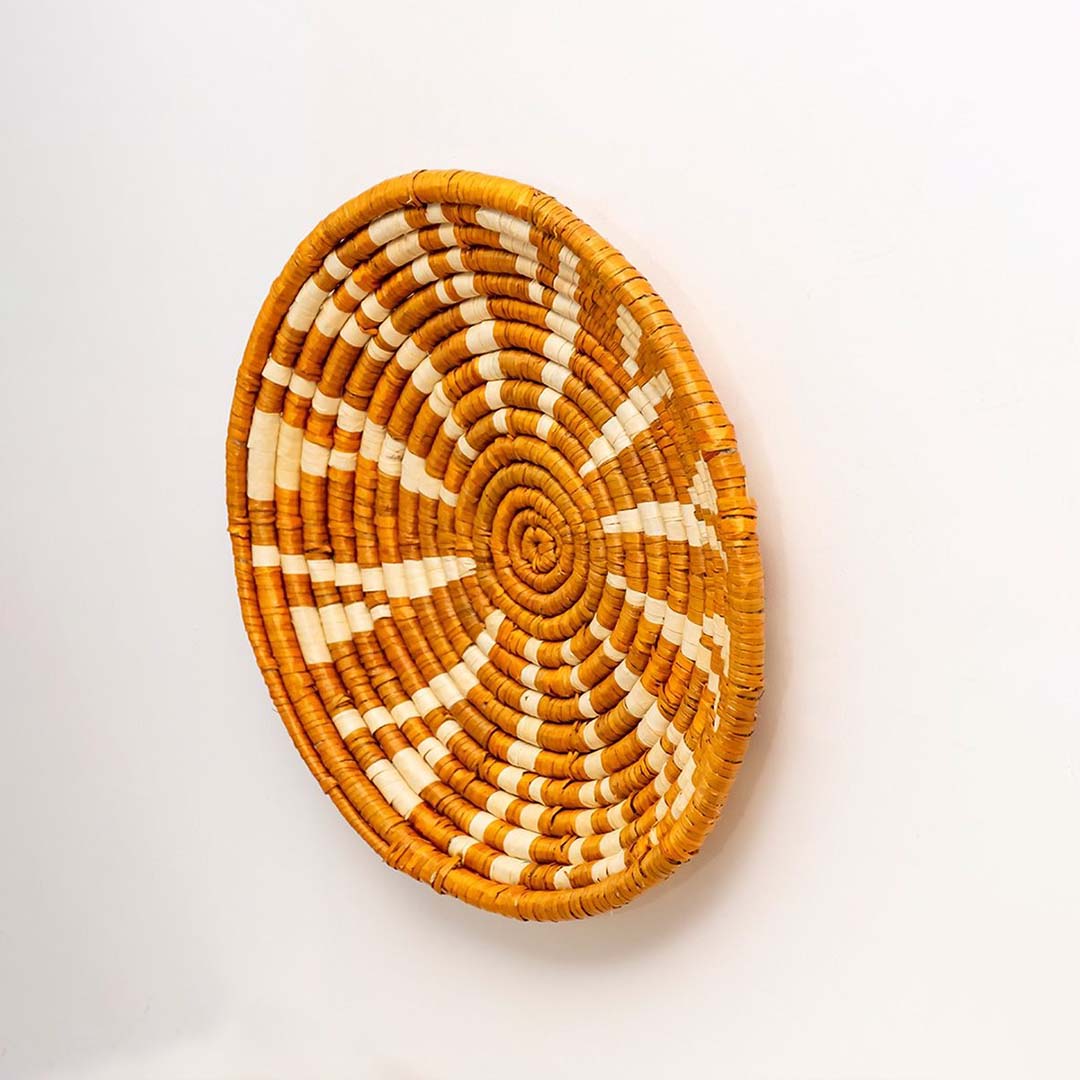 Side view of handcrafted woven basket wall art showing texture depth and intricate weaving details.
