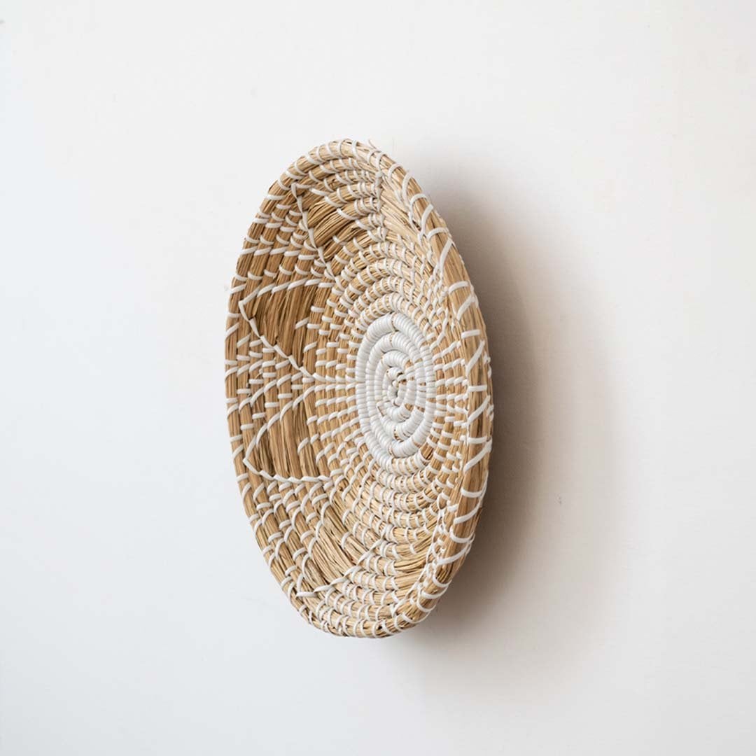 Natural wicker wall basket with white thread accents and round handwoven decor for living room and bedroom walls.
