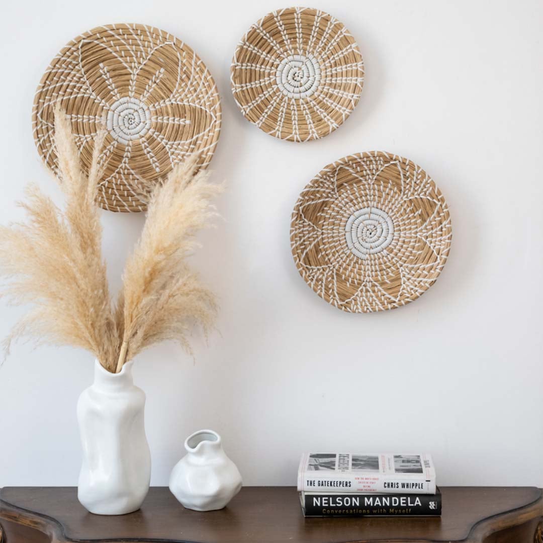 Handwoven wicker basket wall decor with white geometric design styled above console table for home interiors.