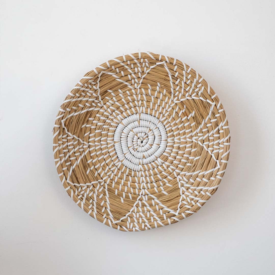 Decorative handwoven basket with natural wicker and white woven pattern for modern wall decor display.