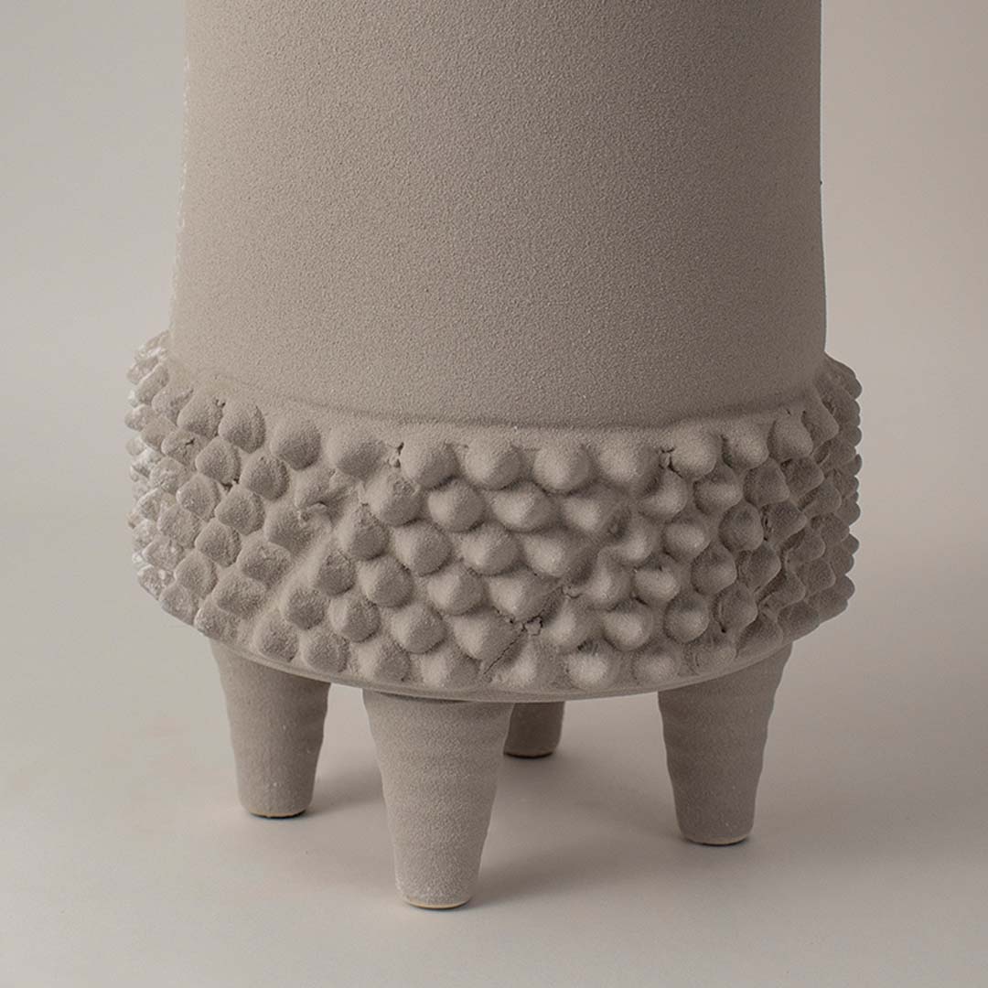 Closeup view of beige ceramic vase highlighting raised dotted texture and matte finish perfect for home interior styling.