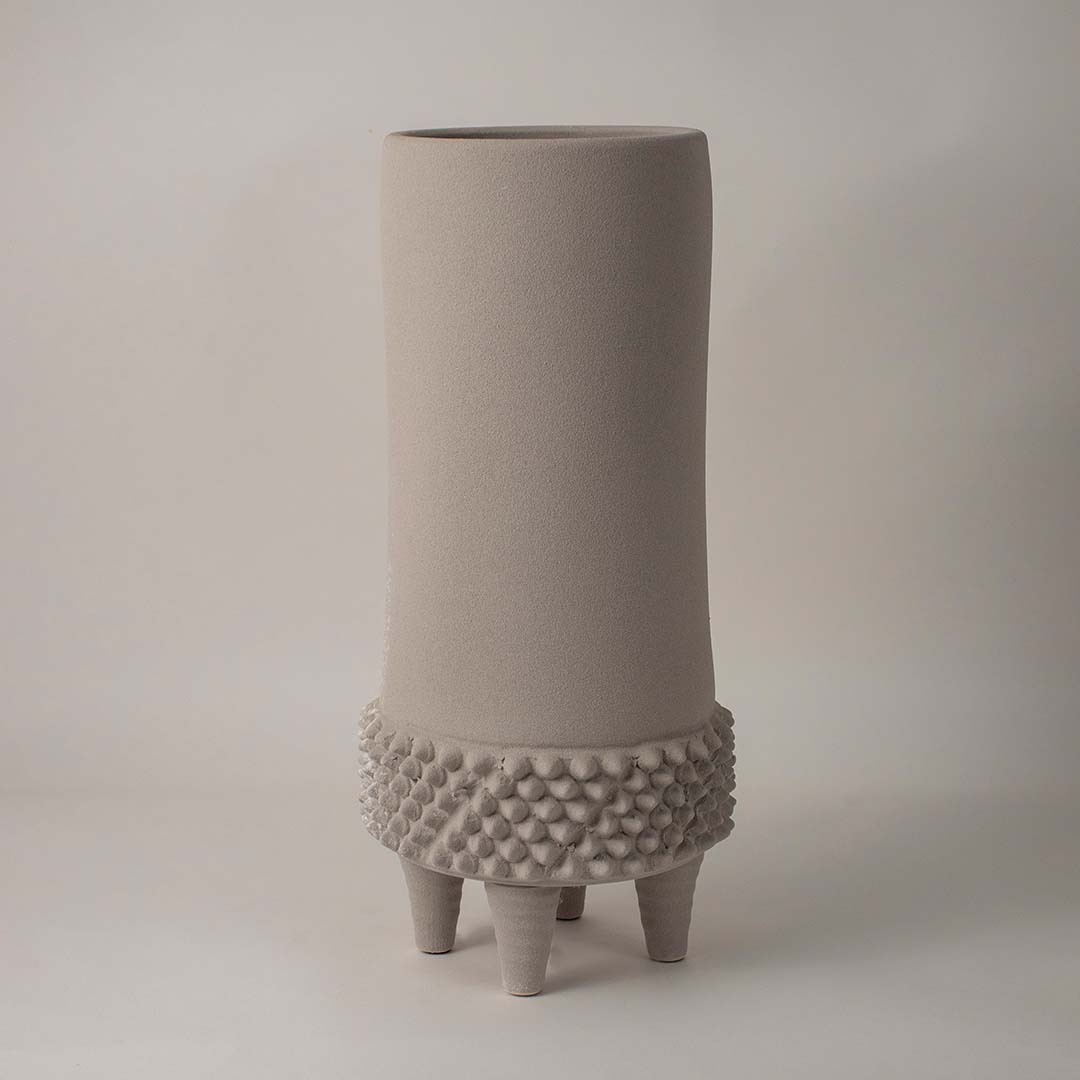 Beige ceramic decorative vase with artistic dotted base displayed on white background for contemporary home decor.