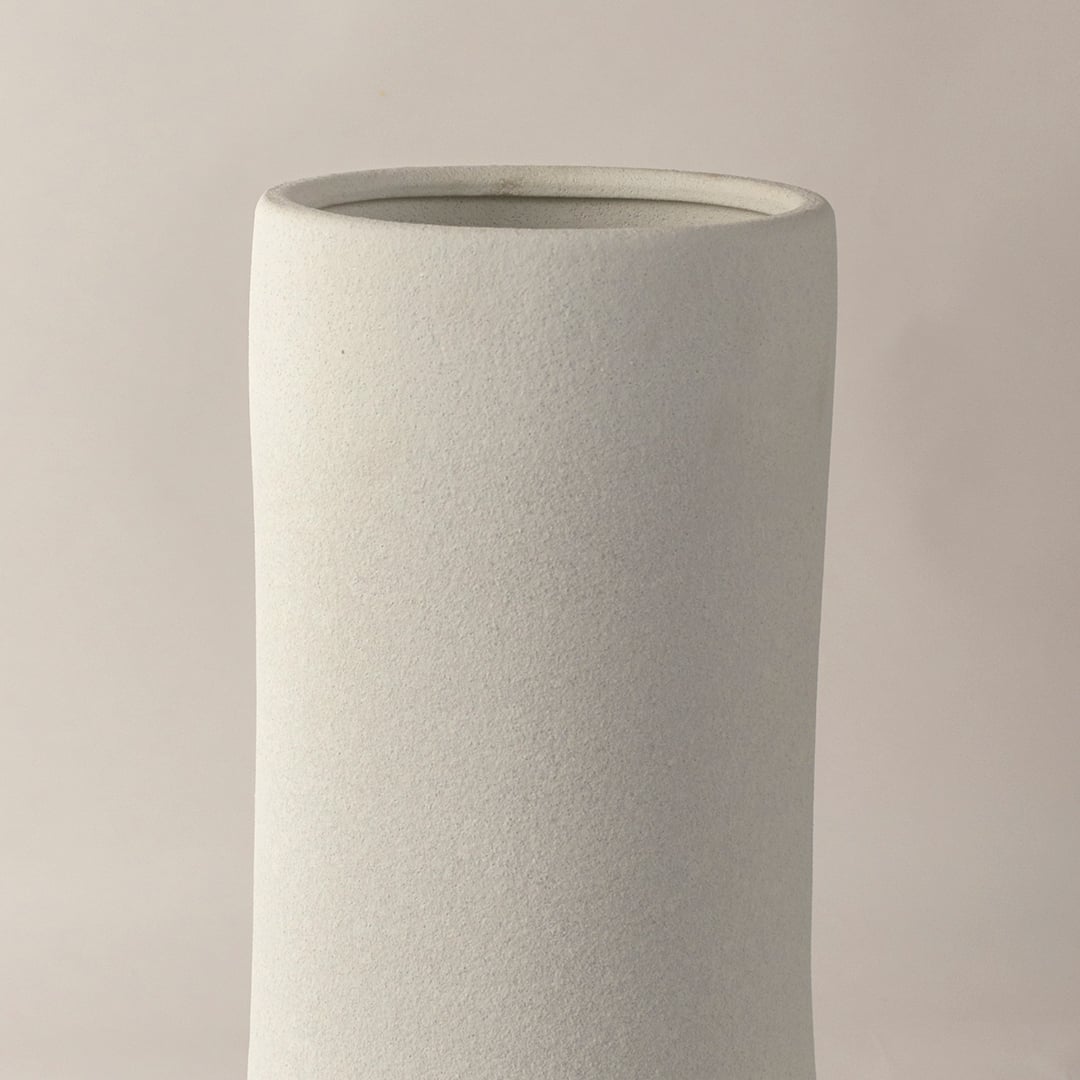 Closeup view of white ceramic vase showing raised textured pattern and matte finish ideal for modern tabletop styling.