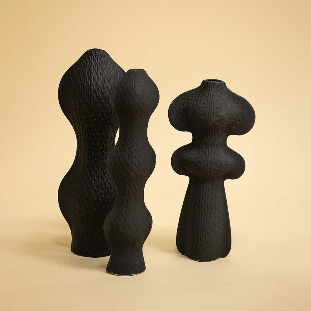 Set of black sculptural vases in modern artistic shapes arranged together for a bold and contemporary decor presentation.