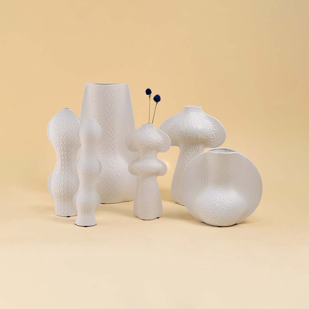 Set of modern white sculptural vases with unique artistic shapes arranged together creating a contemporary home decor look.