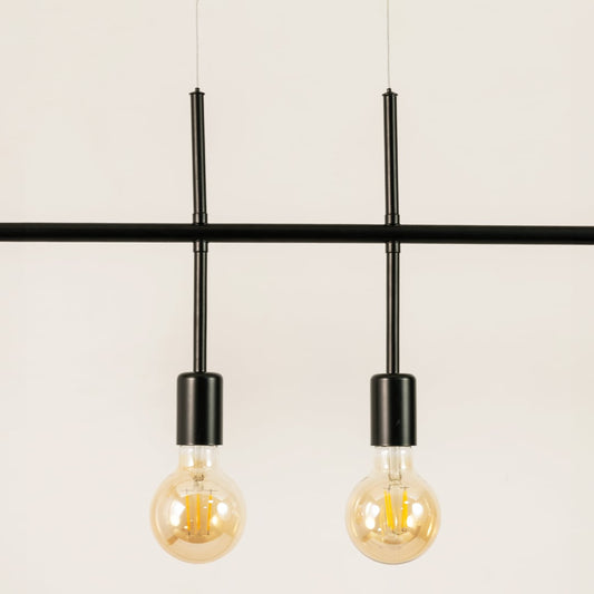 Closeup of black metal linear chandelier showing slim bar frame exposed bulbs and contemporary refined detailing.