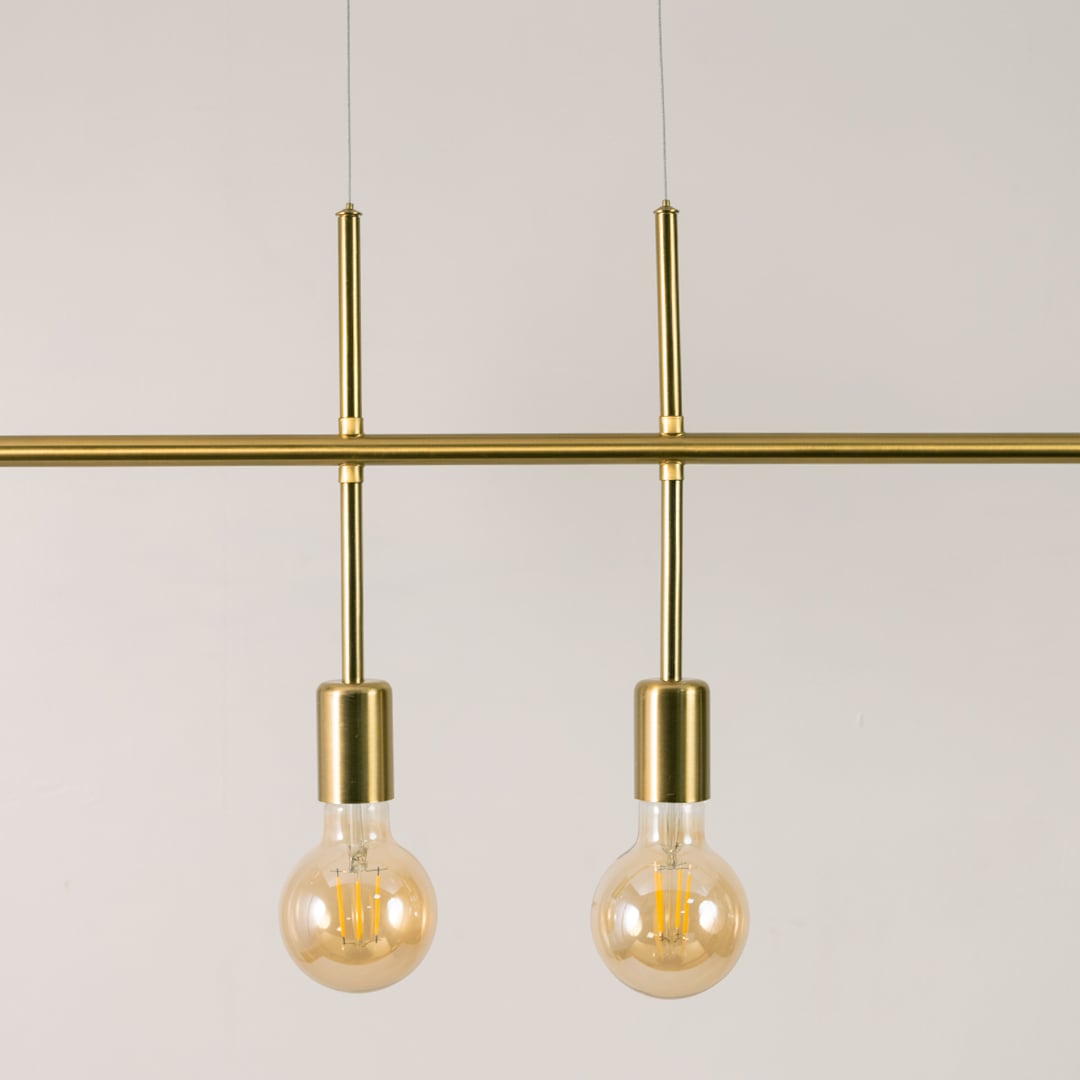 Detailed closeup of gold linear chandelier showing metallic finish bulb holders and smooth streamlined structure.