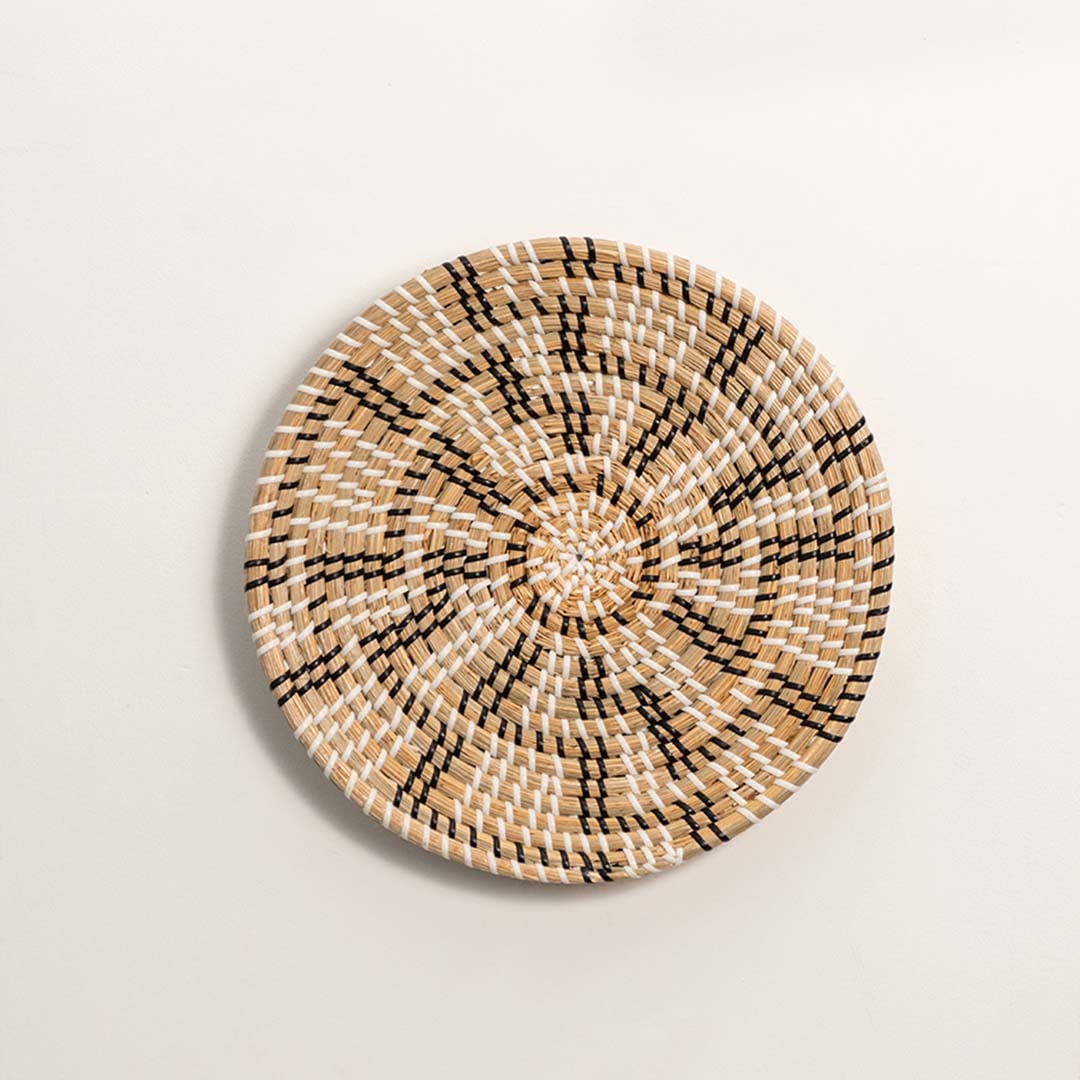 Handwoven woven wall basket in beige and black geometric pattern shown on a plain white background for clear product view.