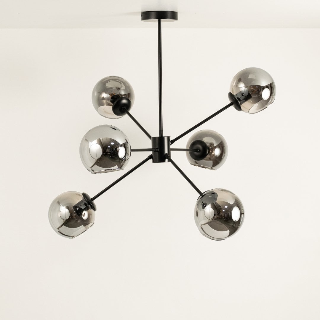 Chrome glass chandelier displayed on white background with lights off showing minimalist black frame and balanced geometric design.