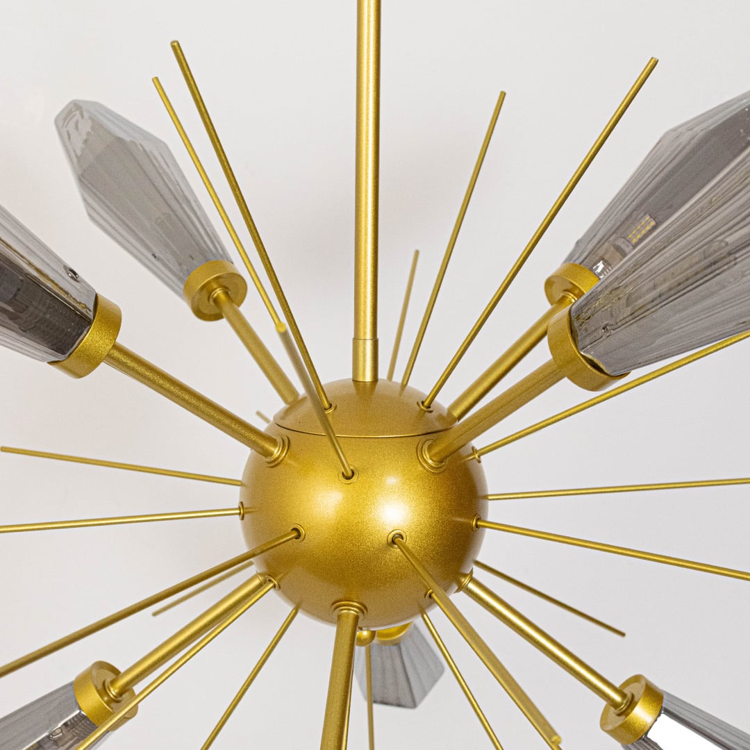 Detailed closeup of gold chandelier showcasing crystal glass detailing  metallic structure  and refined modern craftsmanship.