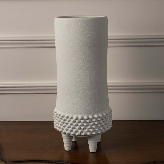 Minimal white ceramic vase displayed on white background with dotted lower texture offering clean modern decor accent.