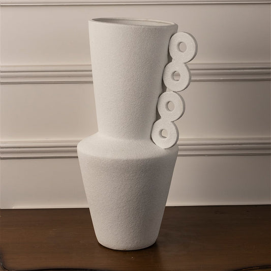 Handcrafted matte white ceramic vase with ring handle design on white background for artistic decor display.