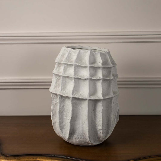 White sculptural ceramic vase displayed on white background with ribbed geometric texture for minimalist modern decor accent.