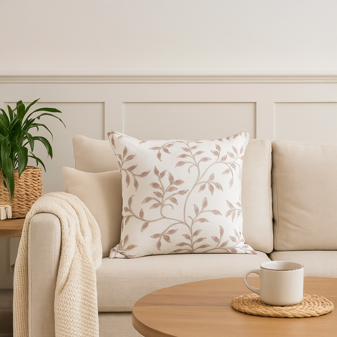 White cotton cushion cover with delicate olive green botanical design styled in a bright living room adding a clean natural décor accent with a soft and skin friendly texture.