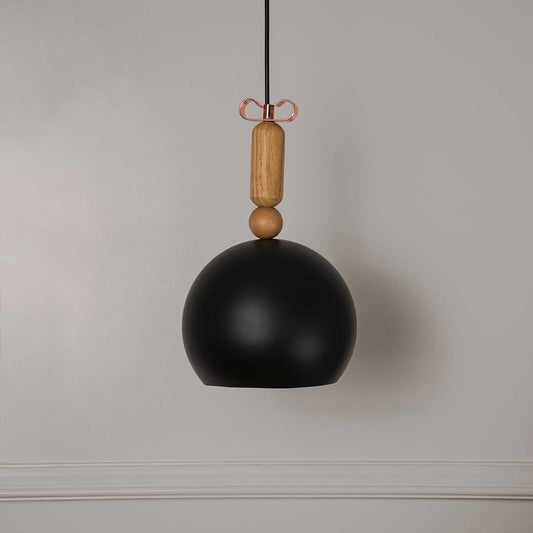 Black dome pendant light with wooden top accent shown off on white background perfect for modern home interiors.