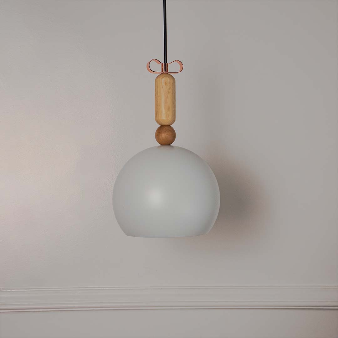 White dome pendant light with wooden top accent shown off on white background for modern interior lighting decor.
